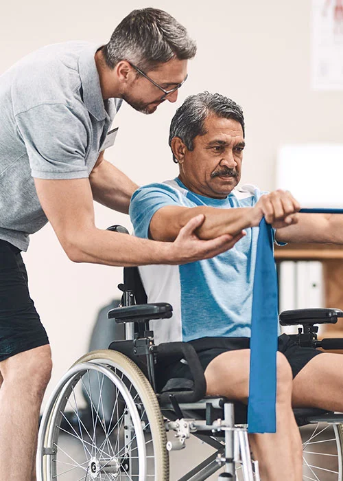 Physical therapist helping a man in a wheelchair do a resistance band exercise